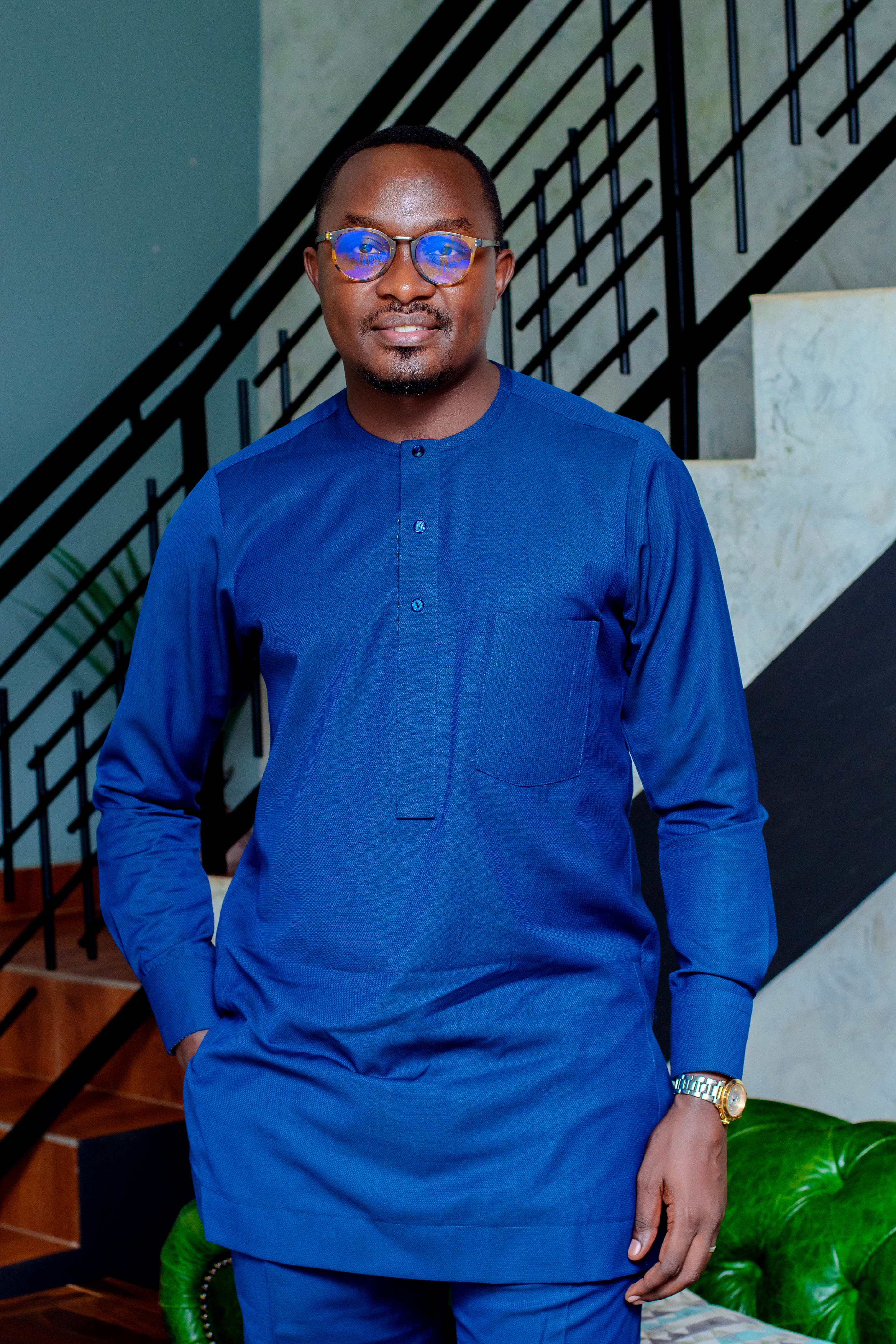 Portrait of a founder in business attire standing in a modern office with floor-to-ceiling windows, mid-30s, confident posture, arms crossed with a slight smile